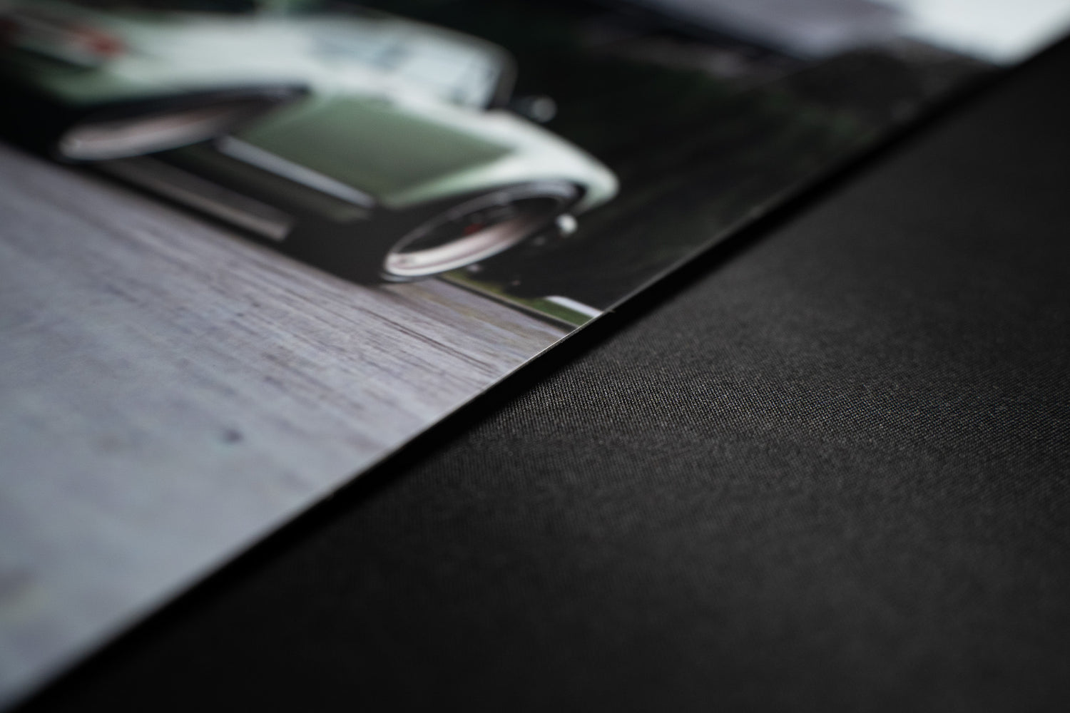 Close-up of edge on large matte metal print of Porsche photo, emphasising sturdy thickness and premium surface.