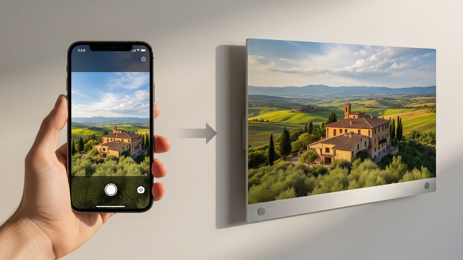 Hand die iPhone vasthoudt bij het vastleggen van een Toscaans landschap naast dezelfde foto als grote glanzende metaaldruk aan de muur