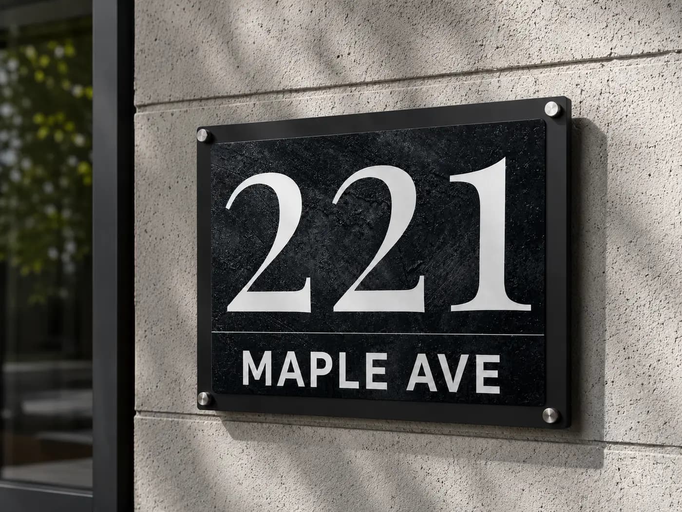 Anthracite concrete metal address sign mounted on an exterior wall with standoff bolts in daylight