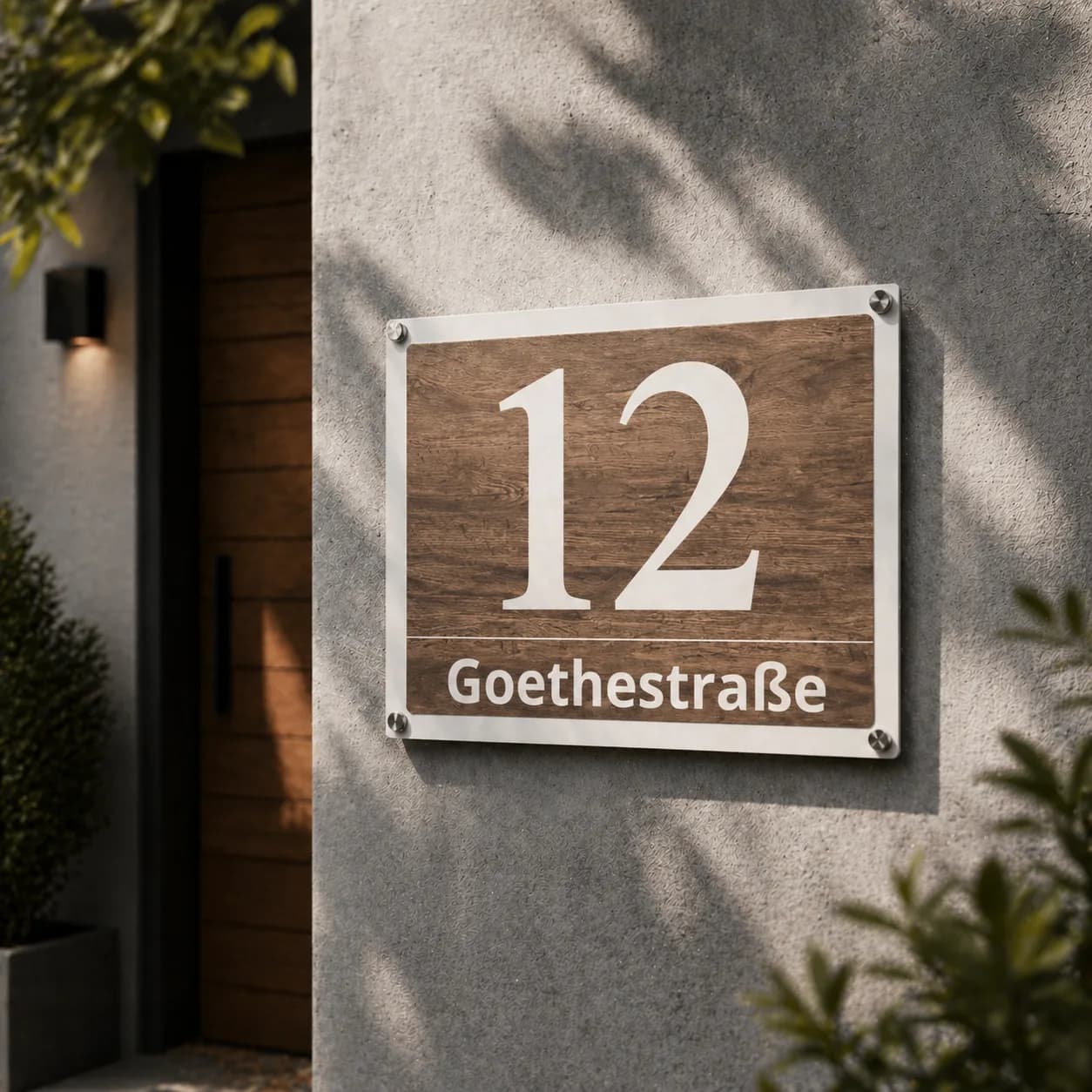 Natural-wood metal address sign with inox standoff bolts at a house entrance