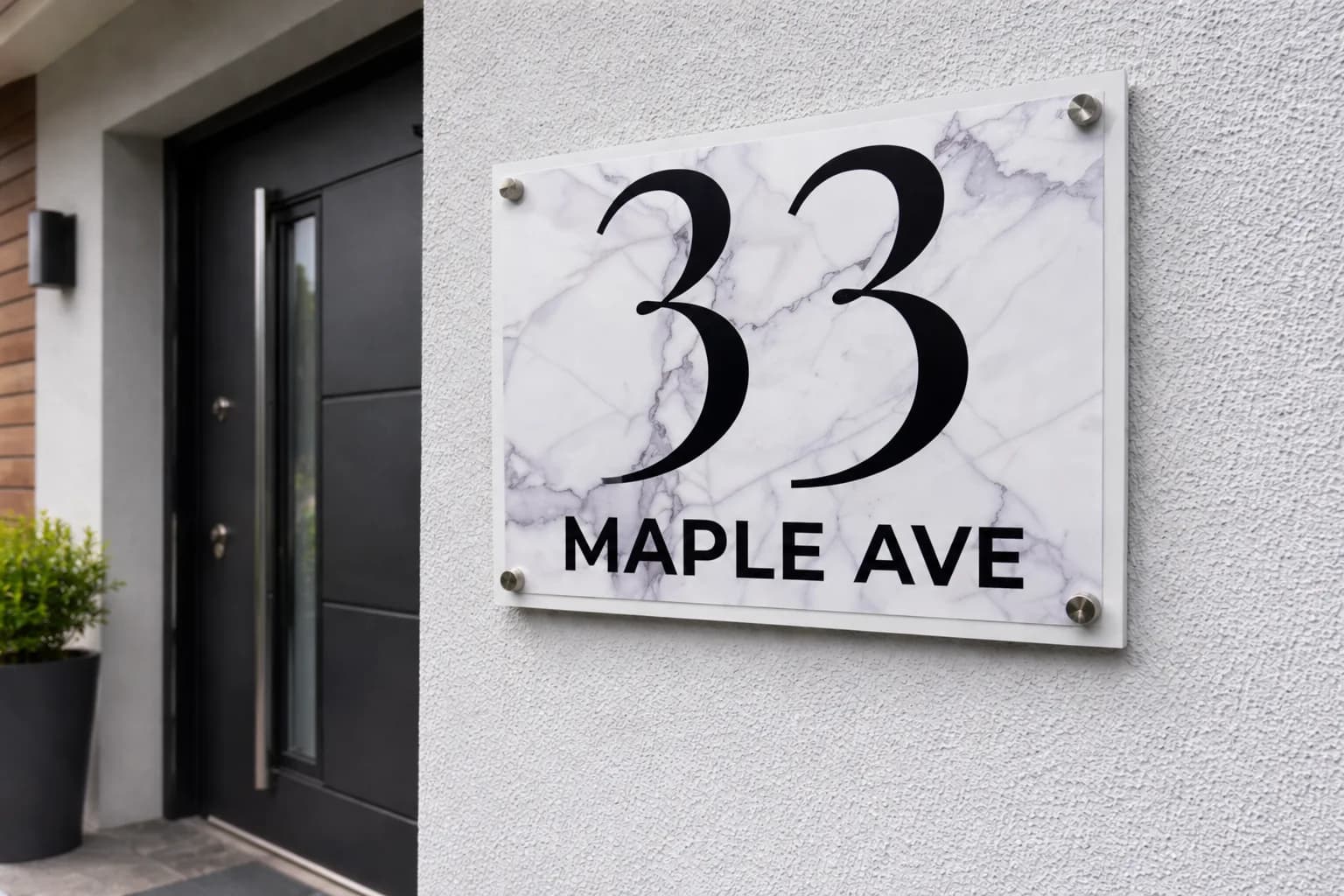 White marble metal address sign with inox standoff bolts beside a modern front door