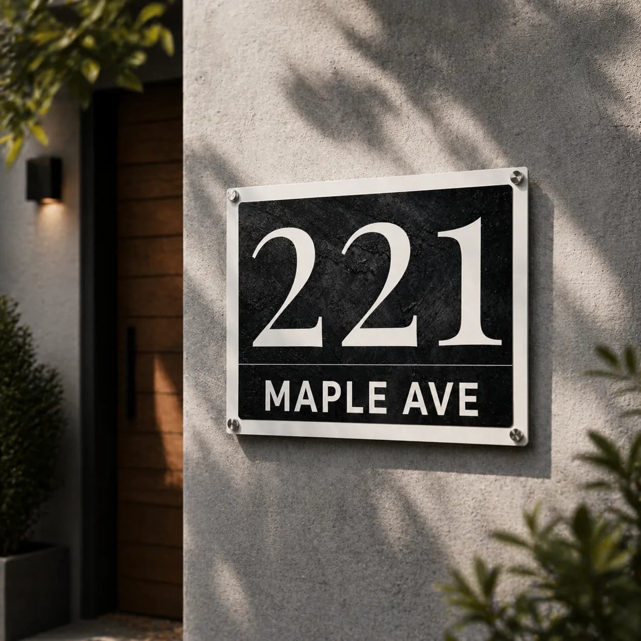 Glossy metal address sign mounted on a modern house wall