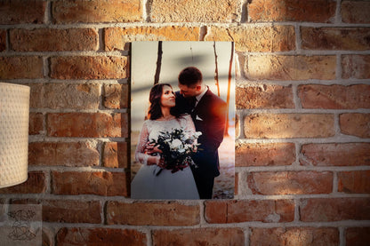 Large matte metal print of bride and groom on brick wall, illustrating rich colour depth for wedding photography.