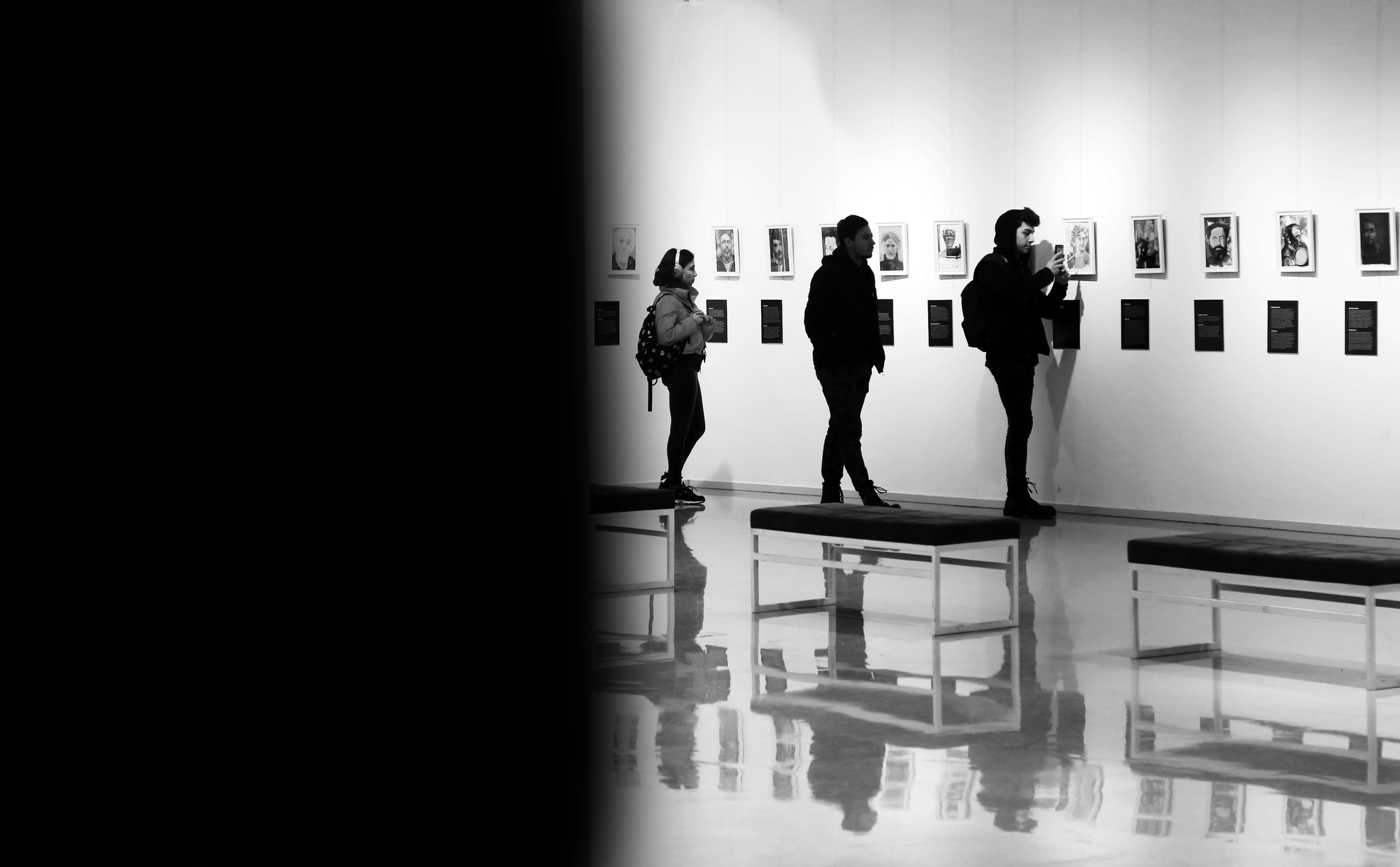 Visitors observing artwork in a gallery — great as inspiration for art-themed custom metal posters or collectible magnets.