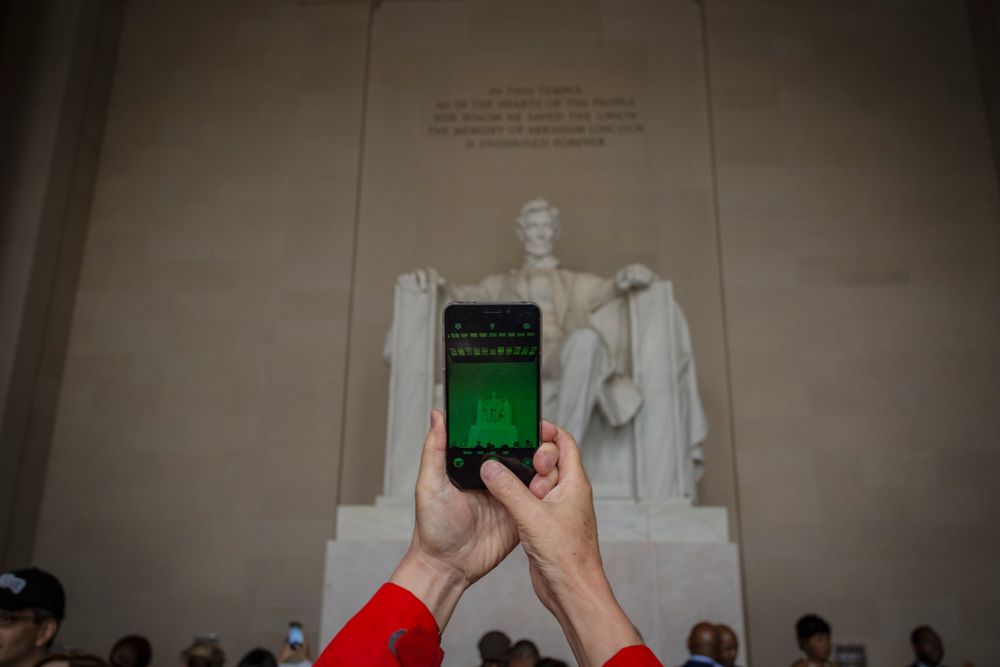 Person taking a photo of the Lincoln Memorial on a smartphone — perfect for custom Washington DC-themed magnets or metal prints.